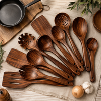 Set de utensilios de teca junto a sartén de hierro y tabla de cortar