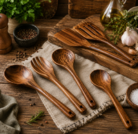 Set de utensilios de teca junto a aceite de oliva, ajo y hierbas